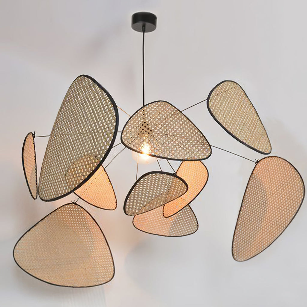 A wide studio angle shows this Clérachic pendant's paddles fanned out around the lit bulb, against a plain grey backdrop.
