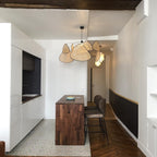 A patterned tile floor runs beneath the dark wood kitchen island where this Clérachic pendant hangs.