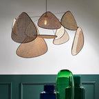 A close view of this Clérachic pendant's paddles sits against a white wall, with green and blue glass vases below.