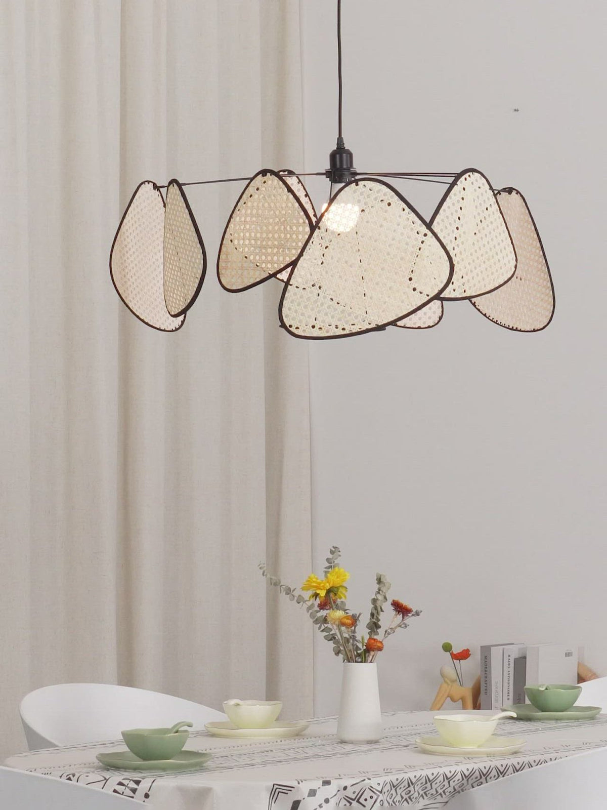 Teacups and flowers sit beneath this Clérachic pendant, hung above a small table in a bright white room.