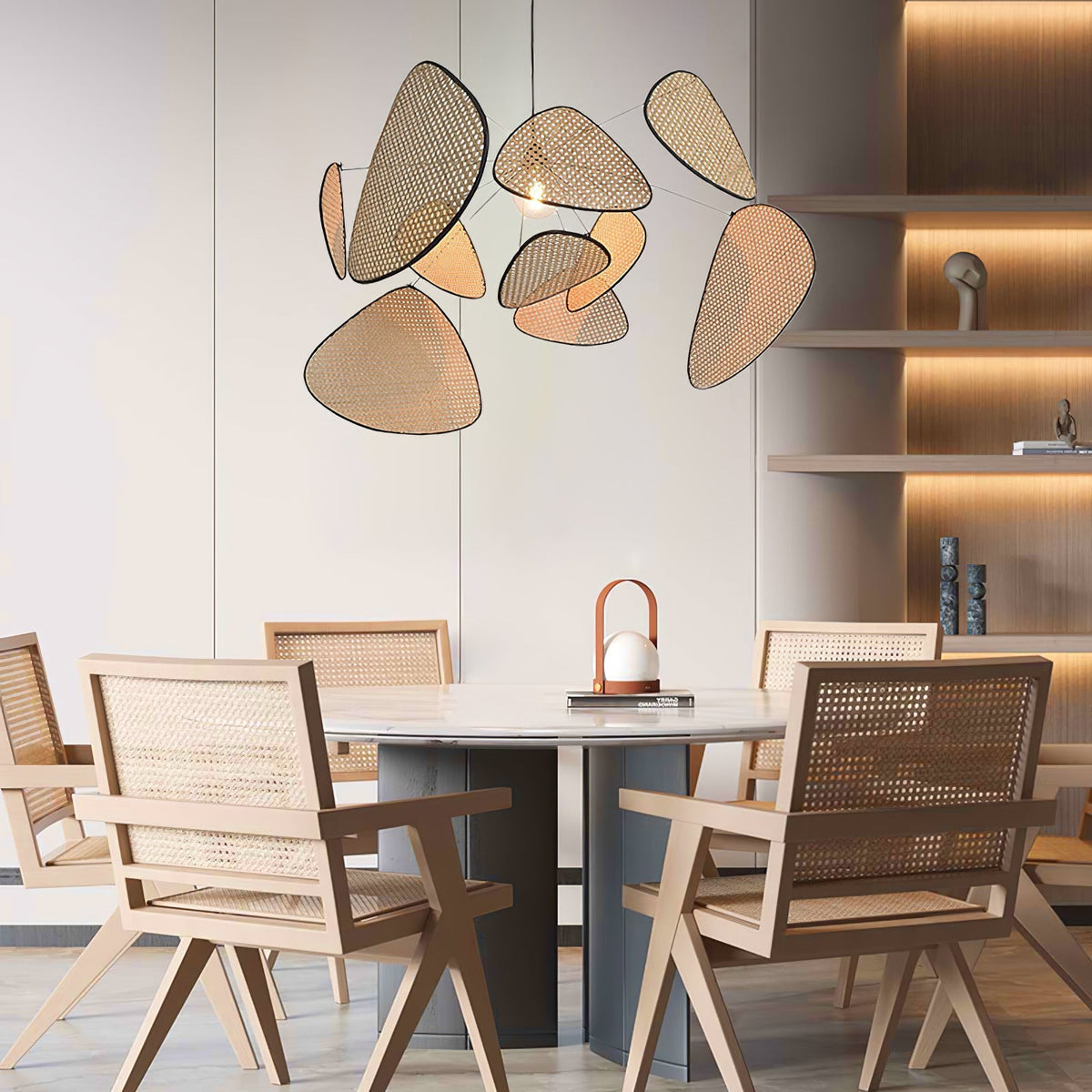 Above a round dining table and pale wood shelving, this Clérachic pendant's bamboo-weave paddles glow warmly.