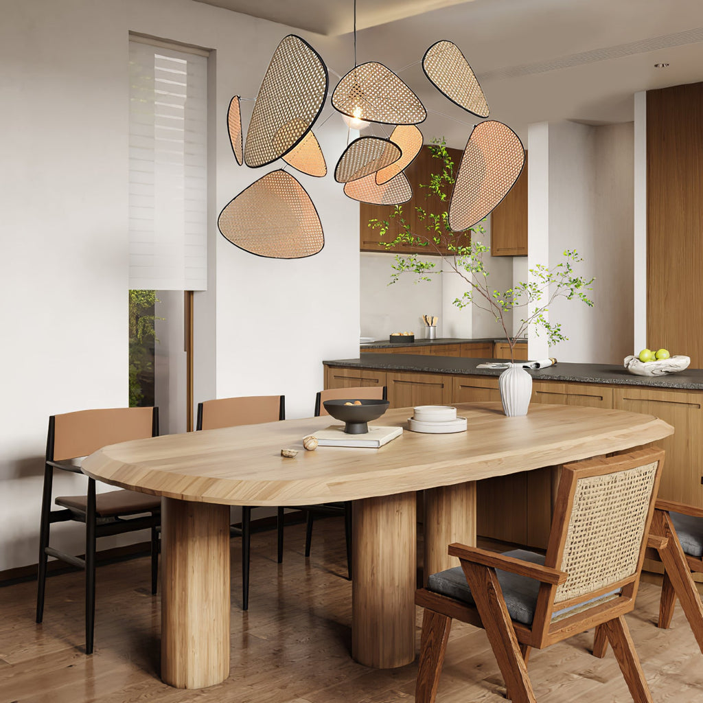 This Clérachic pendant is suspended over an oval wood table in a kitchen with a leafy green plant nearby.
