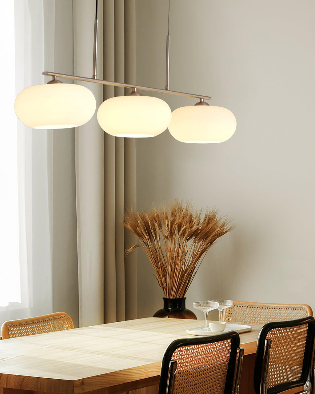 White glass globe shades on a pendant above a dining table