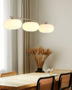 White glass globe shades on a pendant above a dining table