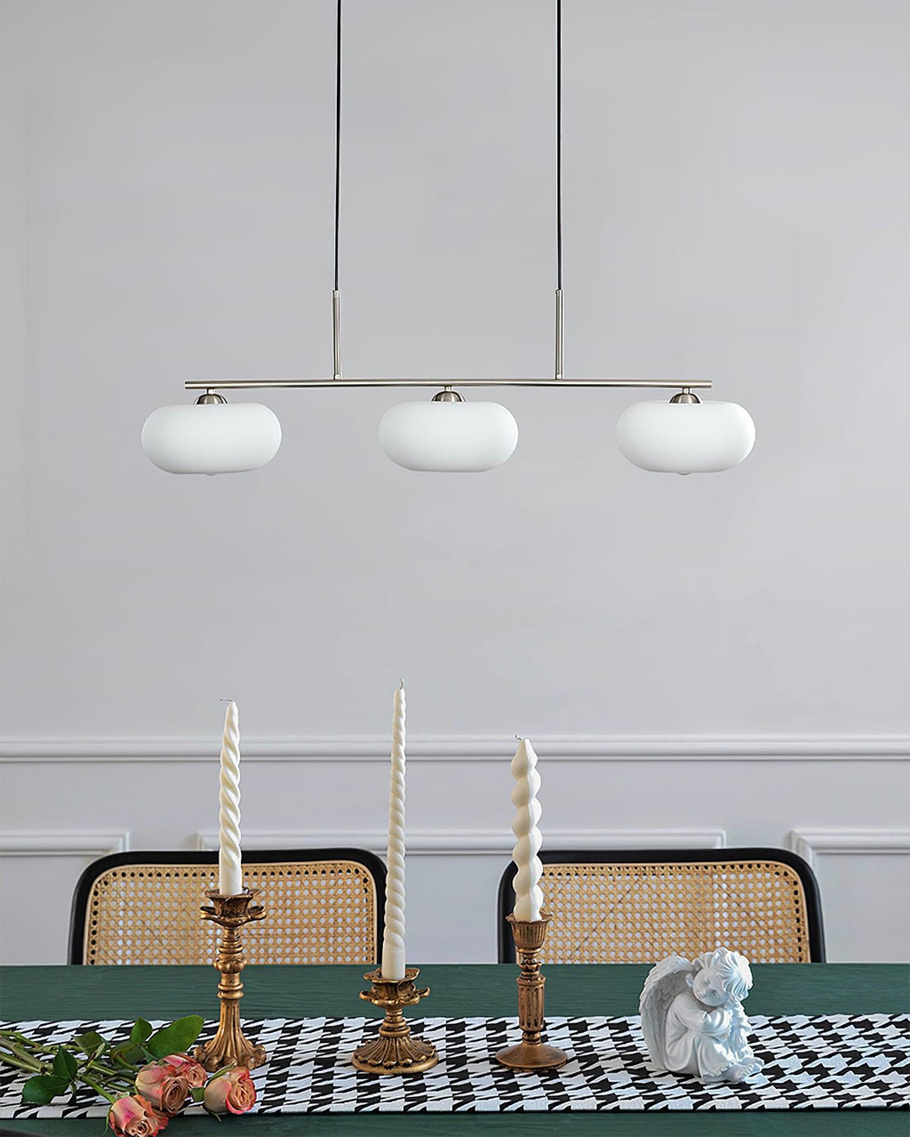 Linear three-globe pendant adding warmth above a table
