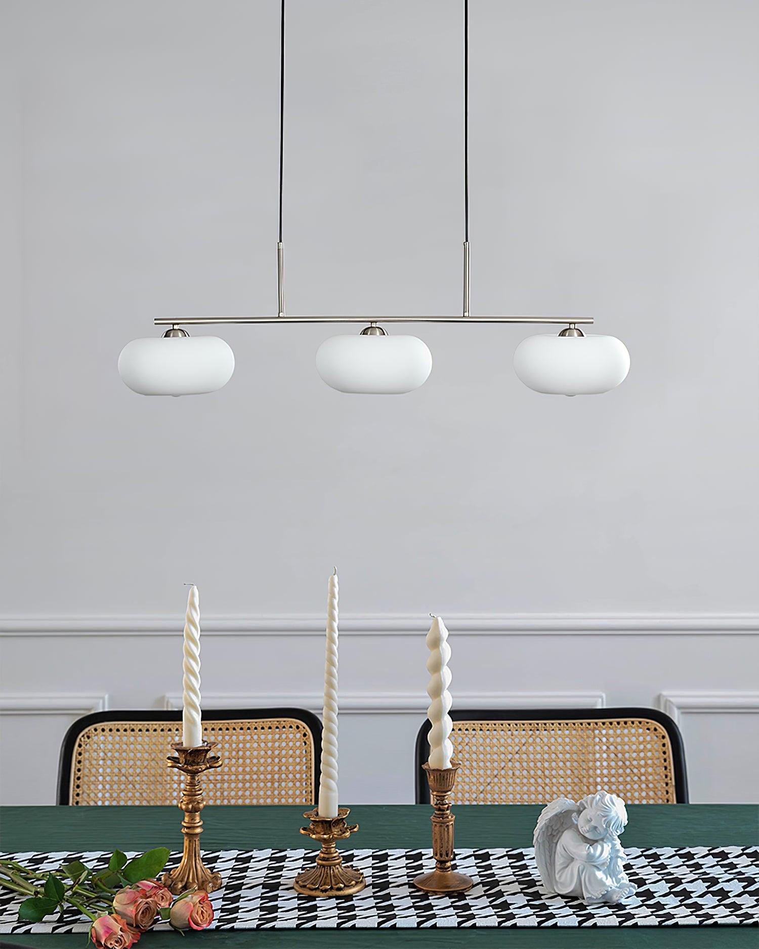 Linear three-globe pendant adding warmth above a table