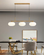 White glass globe pendant light glowing in a styled room