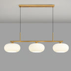 Three globe pendant light glowing above a dining table