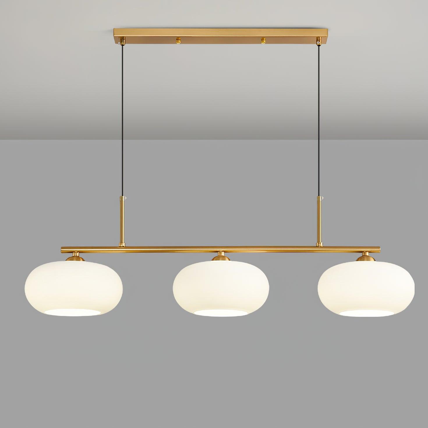 Three globe pendant light glowing above a dining table
