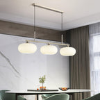 White glass globe shades on a slim linear pendant bar