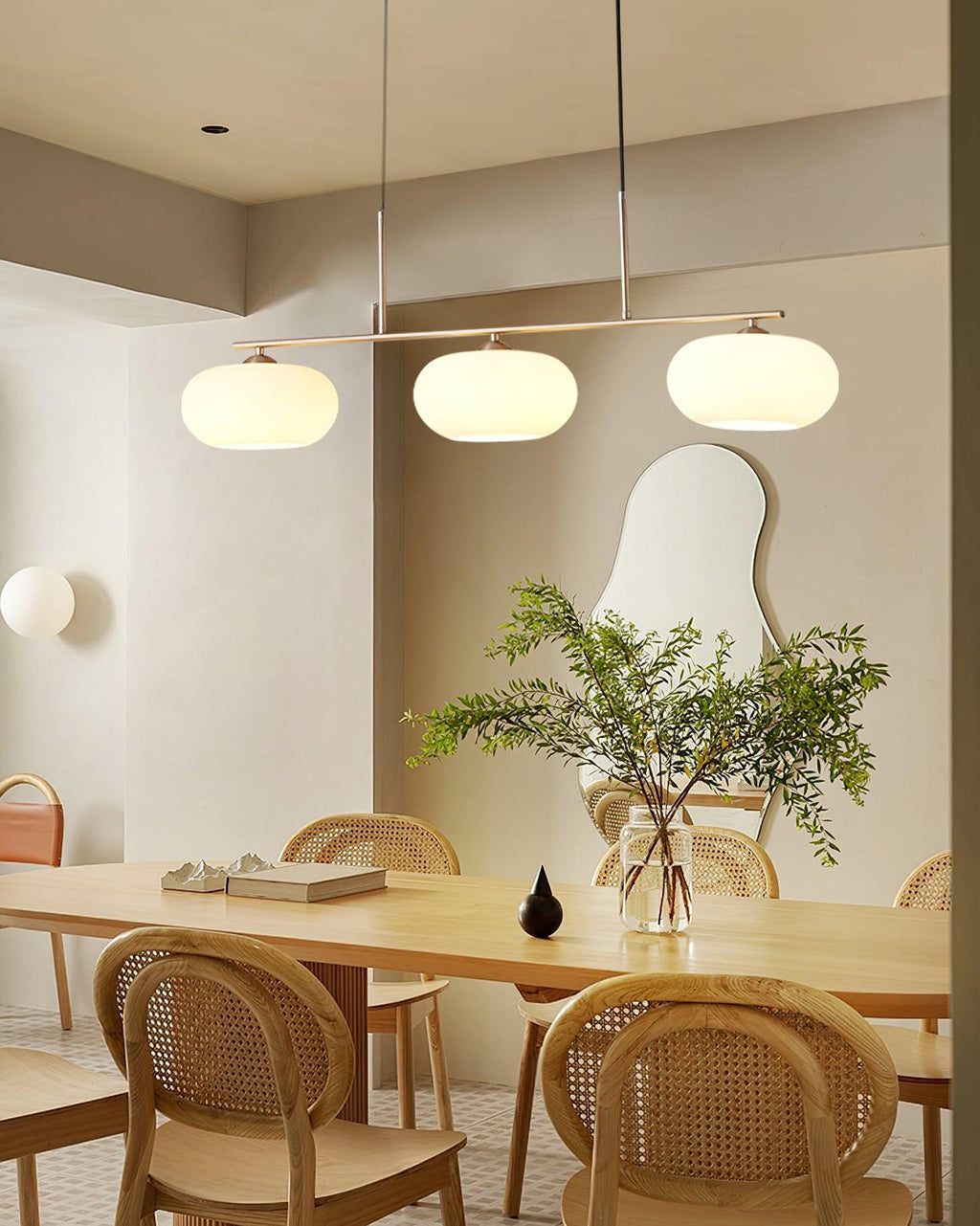 Three-globe pendant light over a styled dining table setting