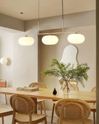 Three-globe pendant light over a styled dining table setting