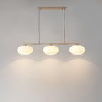 White glass globe pendant glowing above a kitchen island