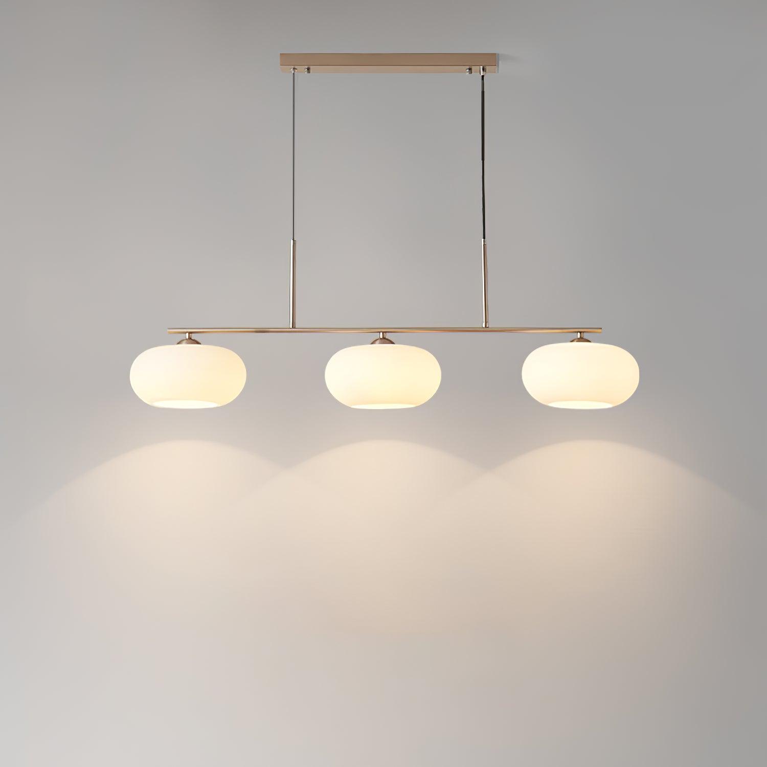 White glass globe pendant glowing above a kitchen island