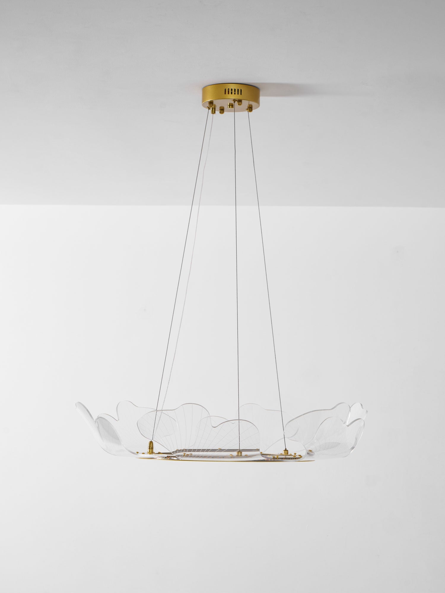 Clear acrylic leaf chandelier lit in a contemporary room
