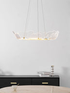 Sea leaf chandelier glowing above a sofa in a living room