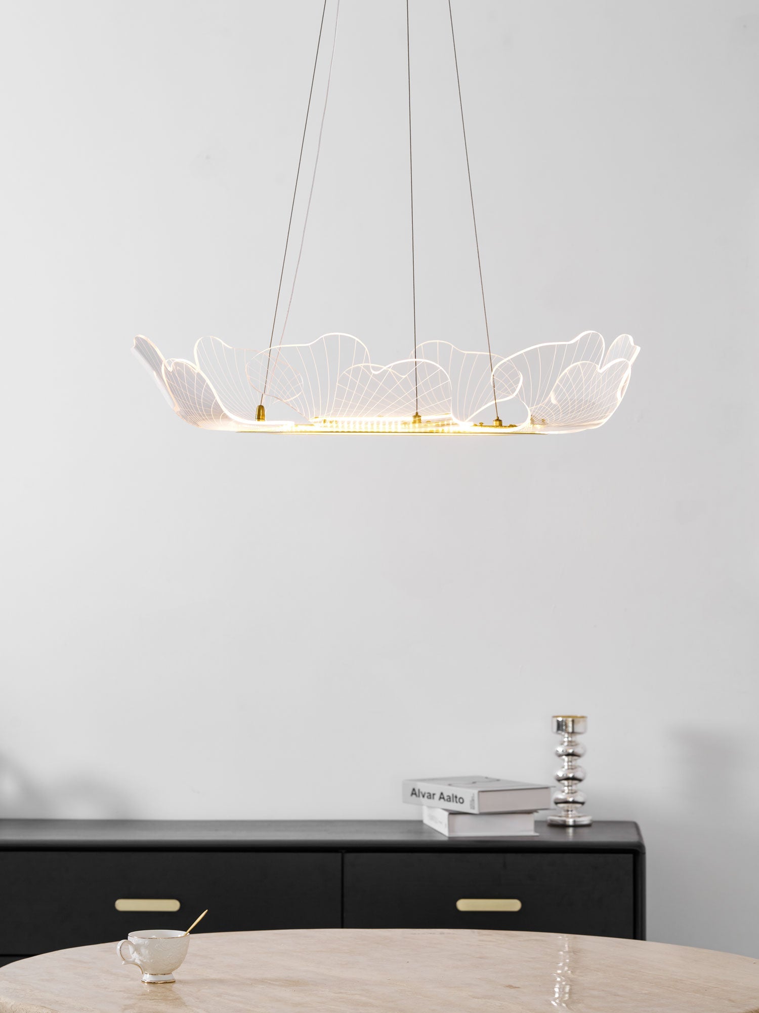 Sea leaf chandelier glowing above a sofa in a living room