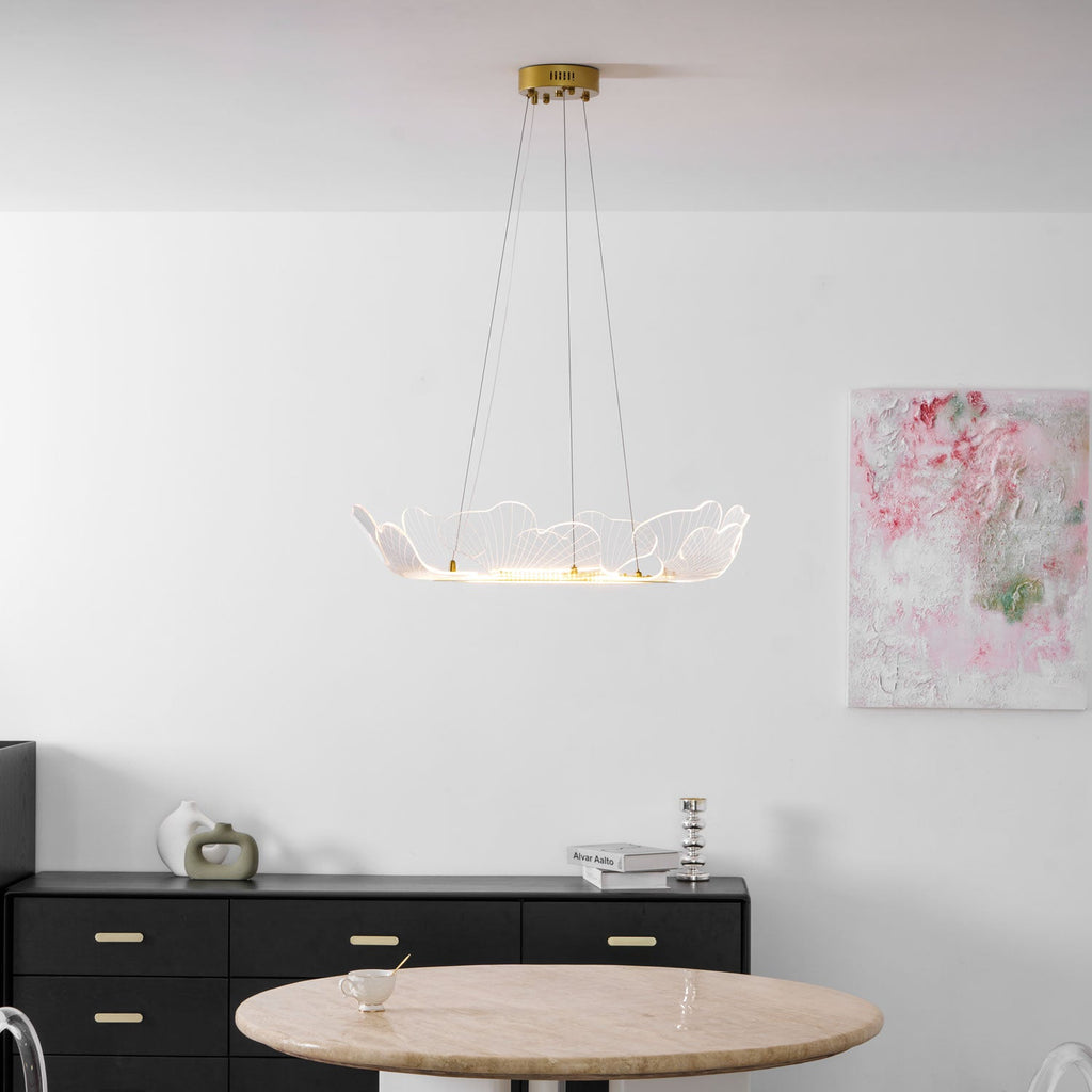 Leaf chandelier in gold finish glowing over a styled table