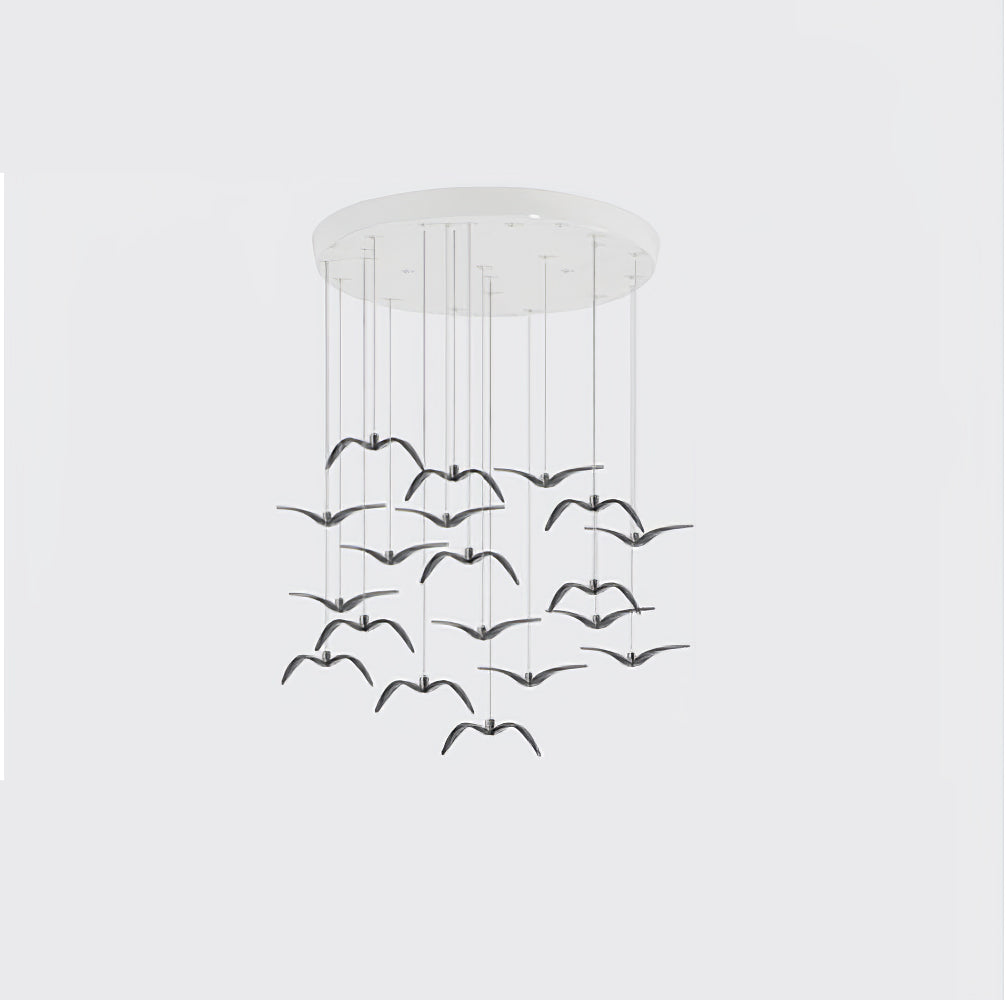 A dense cluster of black bird-shaped pendants from this Clérachic fixture hangs from a round white canopy on a plain backdrop.