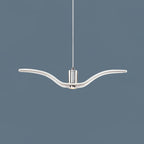 On a slate-blue backdrop, a single white bird-shaped pendant from this Clérachic light hangs with its wings spread wide.