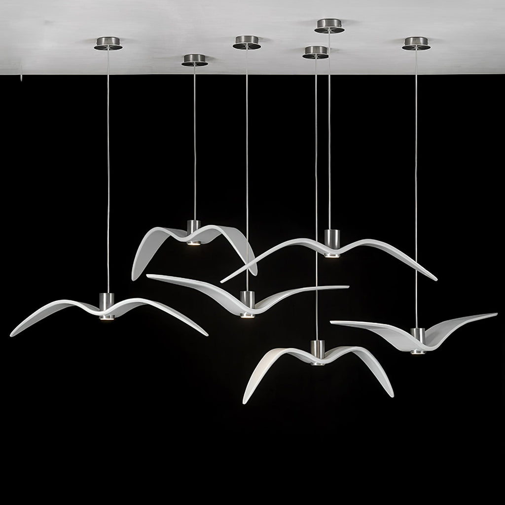 White bird-shaped pendants from this Clérachic fixture hang from a round white canopy against a black backdrop.