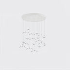 A chandelier of small pale bird-shaped pendants from this Clérachic fixture hangs in tiers from a round white canopy.