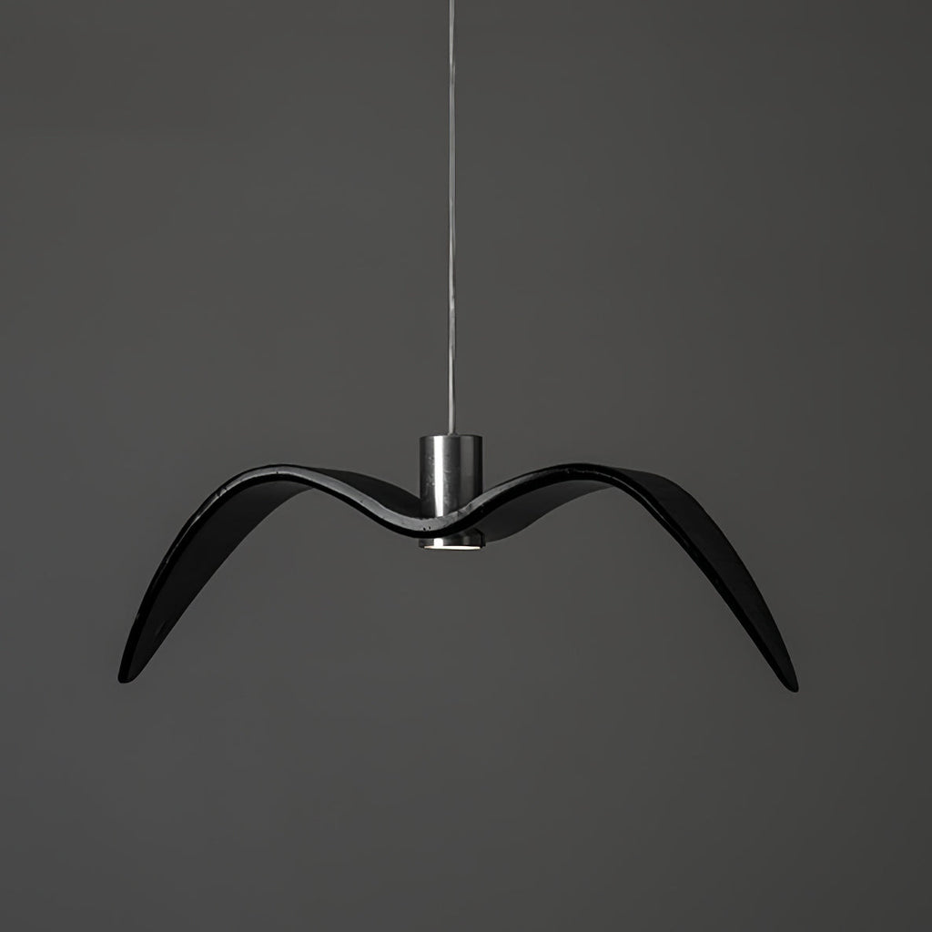 A black bird-shaped pendant from this Clérachic light hangs front-on with wide-spread wings, on a plain dark-grey backdrop.