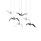 Black and white bird-shaped pendants from this Clérachic fixture hang together at staggered lengths, on a plain white backdrop.