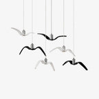 Black and white resin bird pendants from this Clérachic collection cluster together against a plain white backdrop.