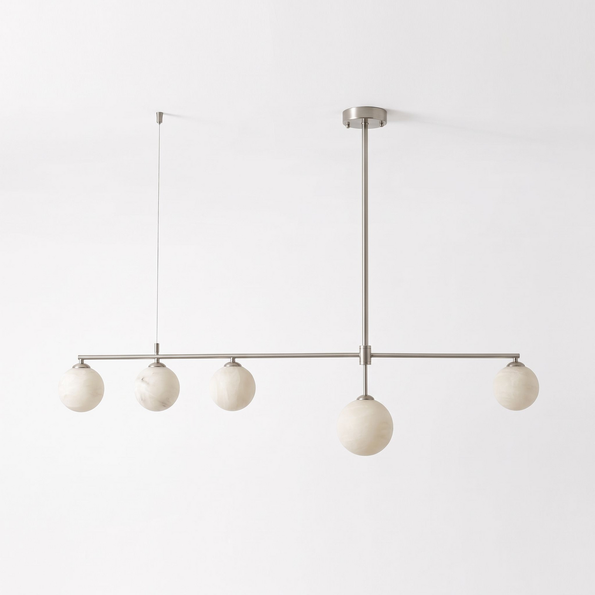 This nickel-finish Clérachic chandelier hangs unlit on a plain white background, its five alabaster balls level.