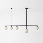 This matte black Clérachic chandelier stands unlit on a plain white background, its five alabaster balls in a row.