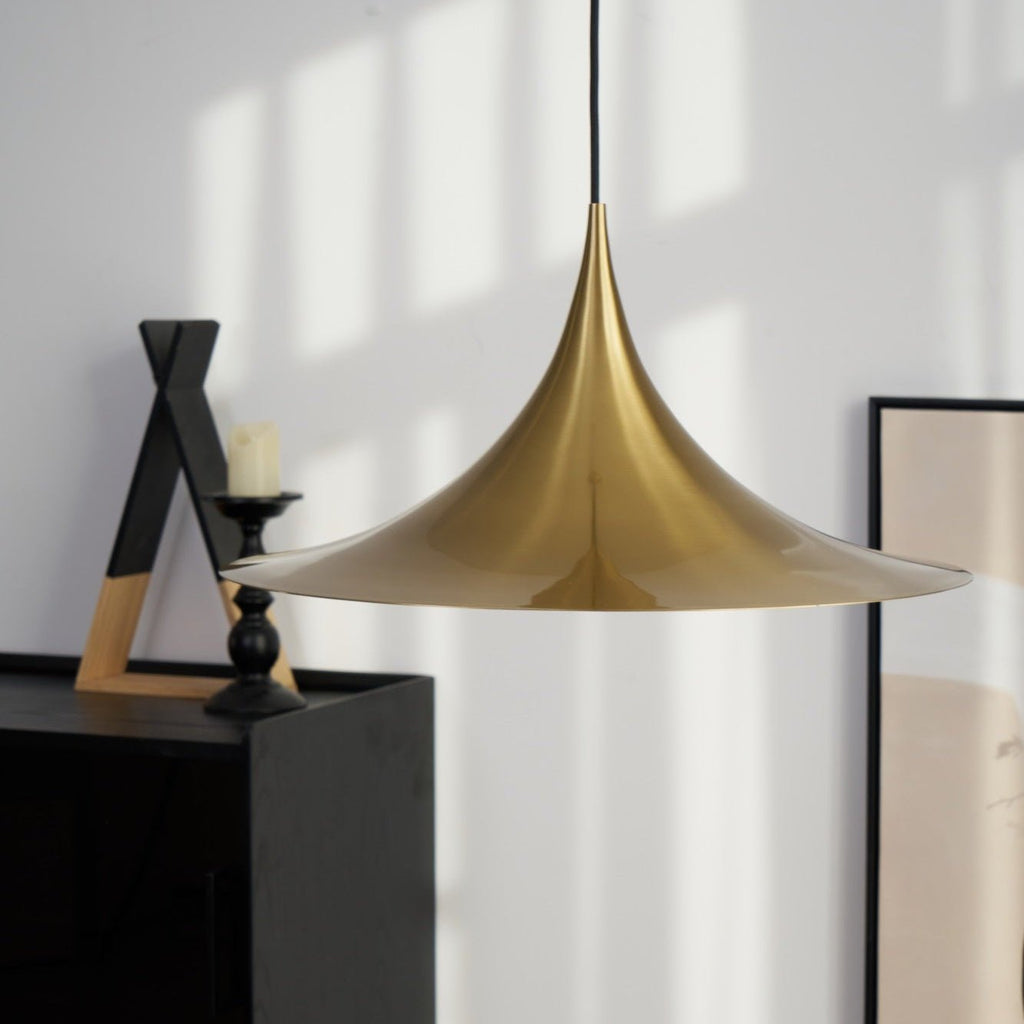 Gold arch pendant light glowing above a dining table