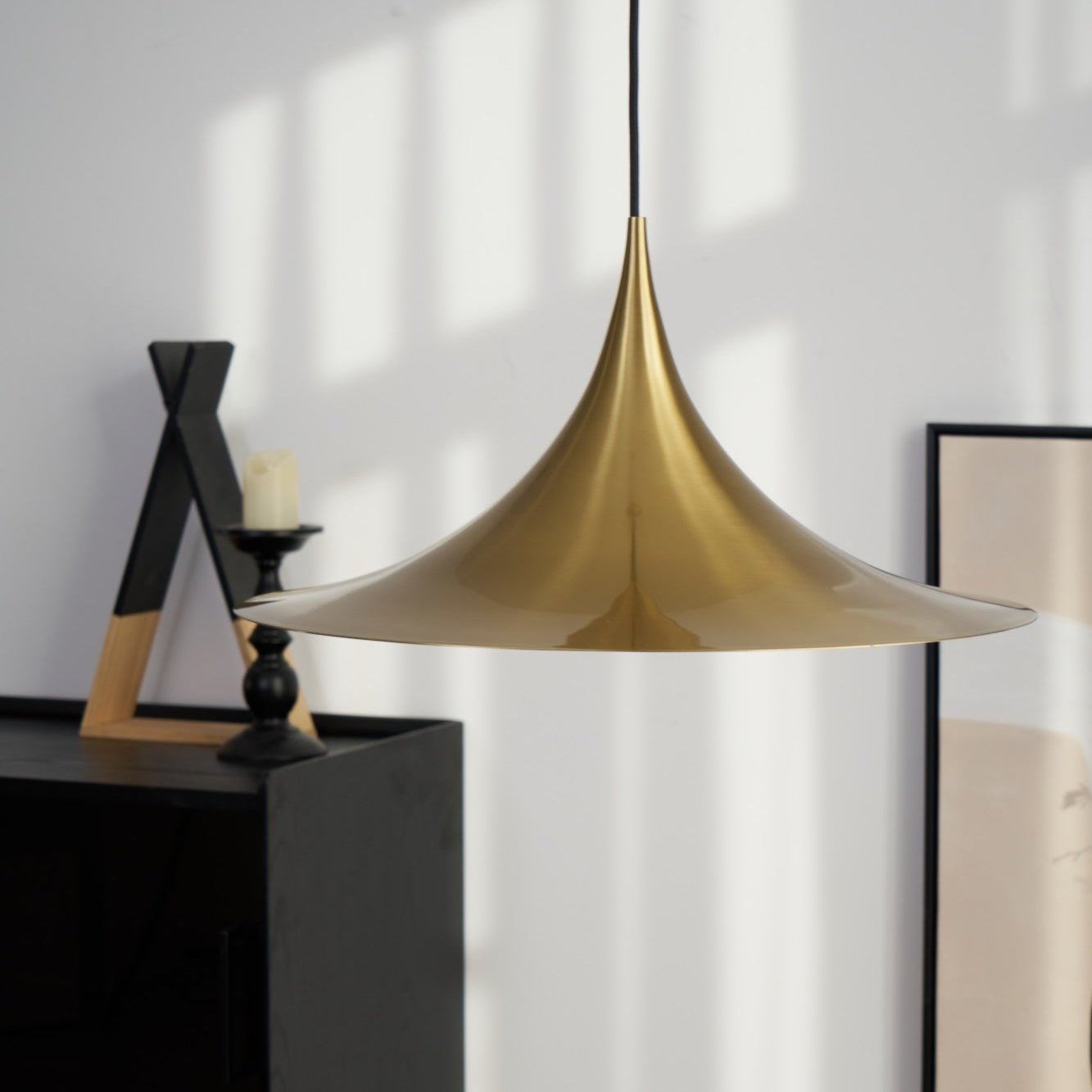 Gold arch pendant light glowing above a dining table