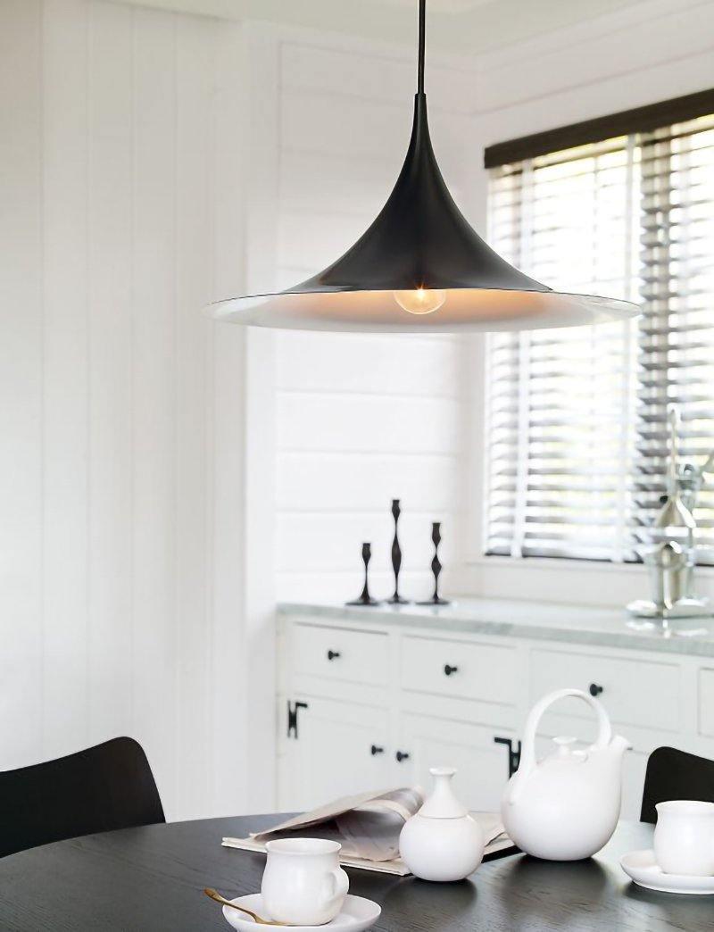 Arch pendant light shown above a styled sideboard