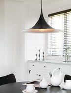 Arch pendant light shown above a styled sideboard