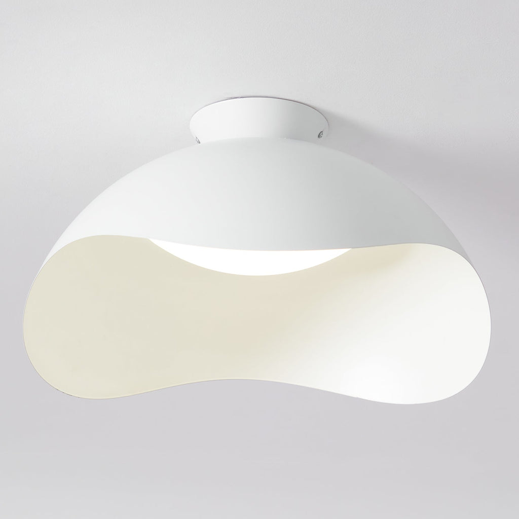 Close view of the wave-cut shade on this Clérachic ceiling light, with light spilling from the curved opening.