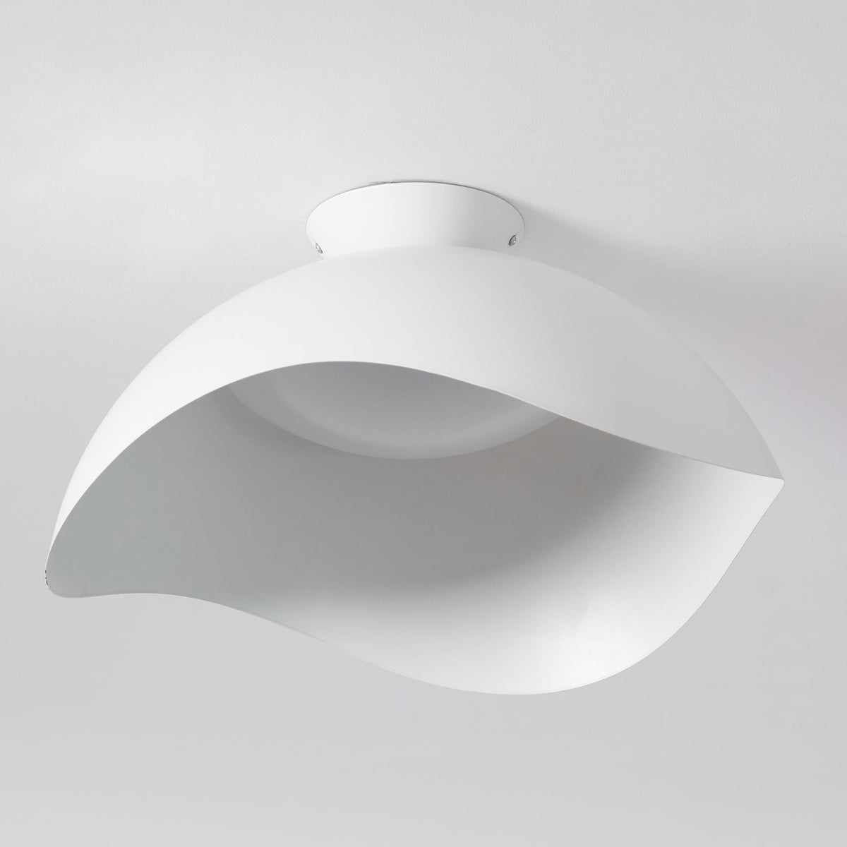 Directly below on a plain grey ceiling, the wave silhouette of this Clérachic light appears unlit and matte.