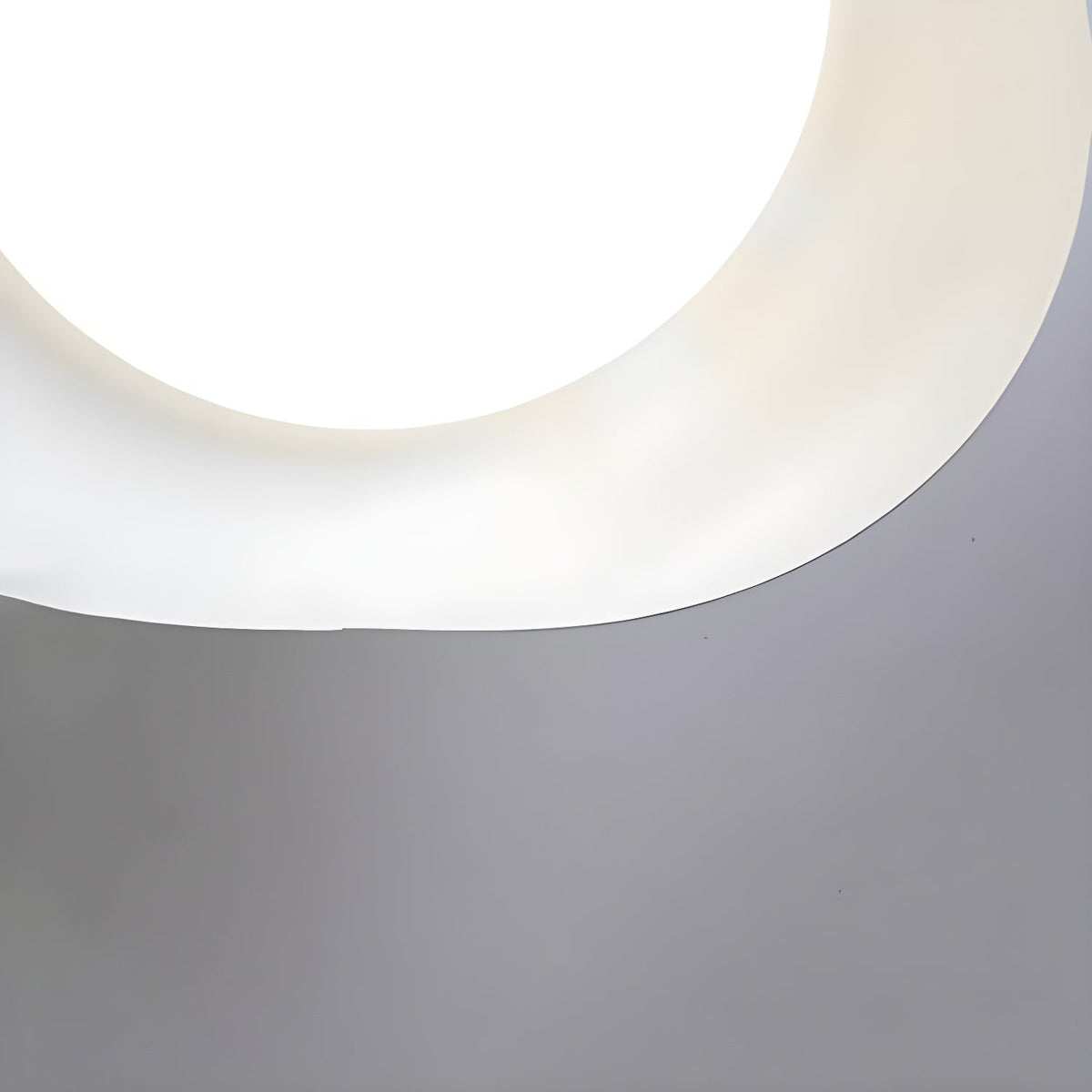 Detail of the smooth curved edge on this Clérachic ceiling light's shade, lit white from within.