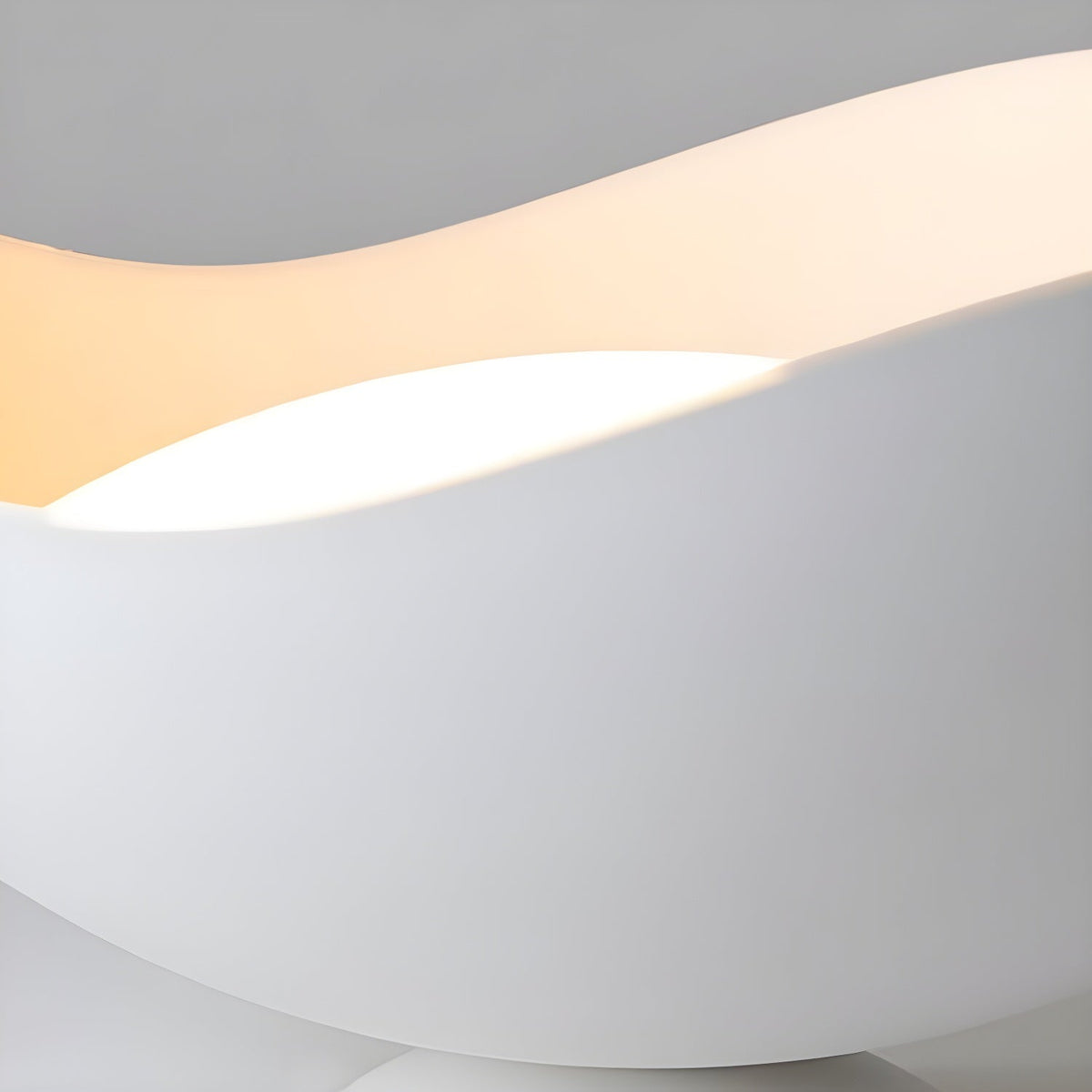 Close view of the wave-cut edge on this Clérachic ceiling light, its curve shifting from warm to white light.