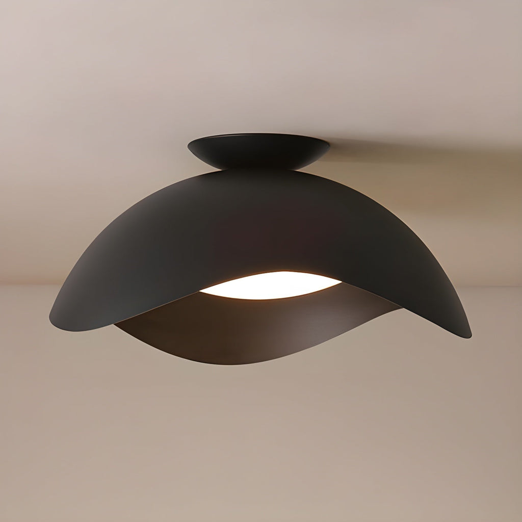In black, this Clérachic ceiling light hangs against a warm beige wall, its wave shade glowing softly beneath.
