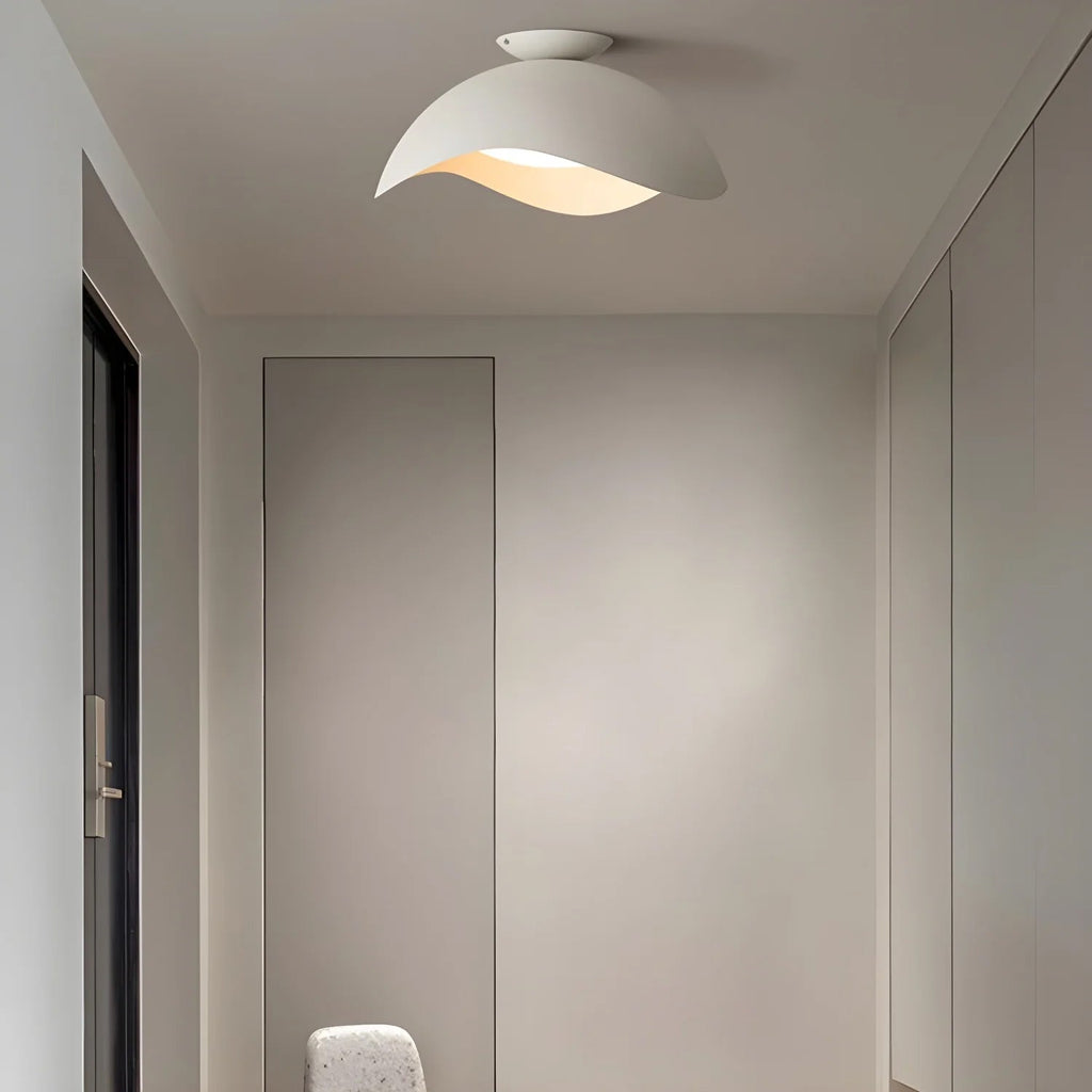 Fitted in a narrow hallway near closet doors, this Clérachic wave ceiling light glows warm from the ceiling.