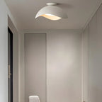 Fitted in a narrow hallway near closet doors, this Clérachic wave ceiling light glows warm from the ceiling.
