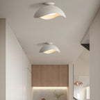Two of this Clérachic wave ceiling light run down a hallway, leading toward a warmly lit kitchen beyond.