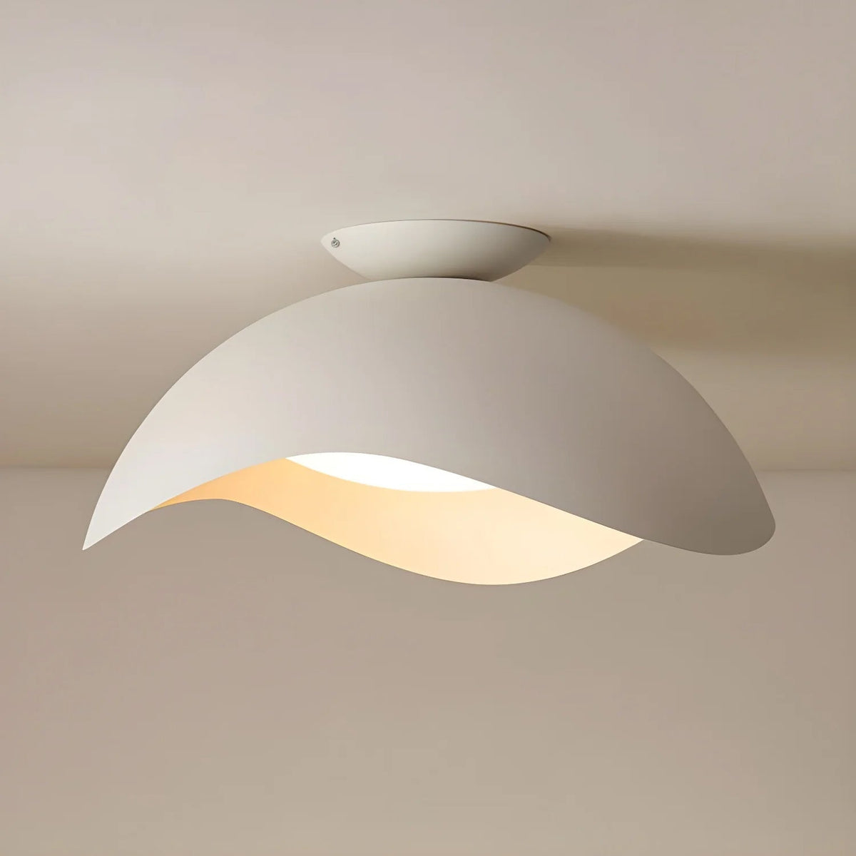 This Clérachic ceiling light in white glows warm against a beige backdrop, its oval canopy visible at the ceiling.