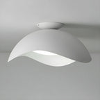 On a plain grey backdrop, this Clérachic wave ceiling light appears in a cooler white tone, unlit.