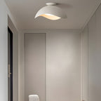 Fitted above a hallway corridor, this Clérachic wave ceiling light casts warm light onto closet doors nearby.