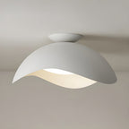 On a plain grey ceiling, this Clérachic wave ceiling light shows its rounded canopy and gently curved shade.