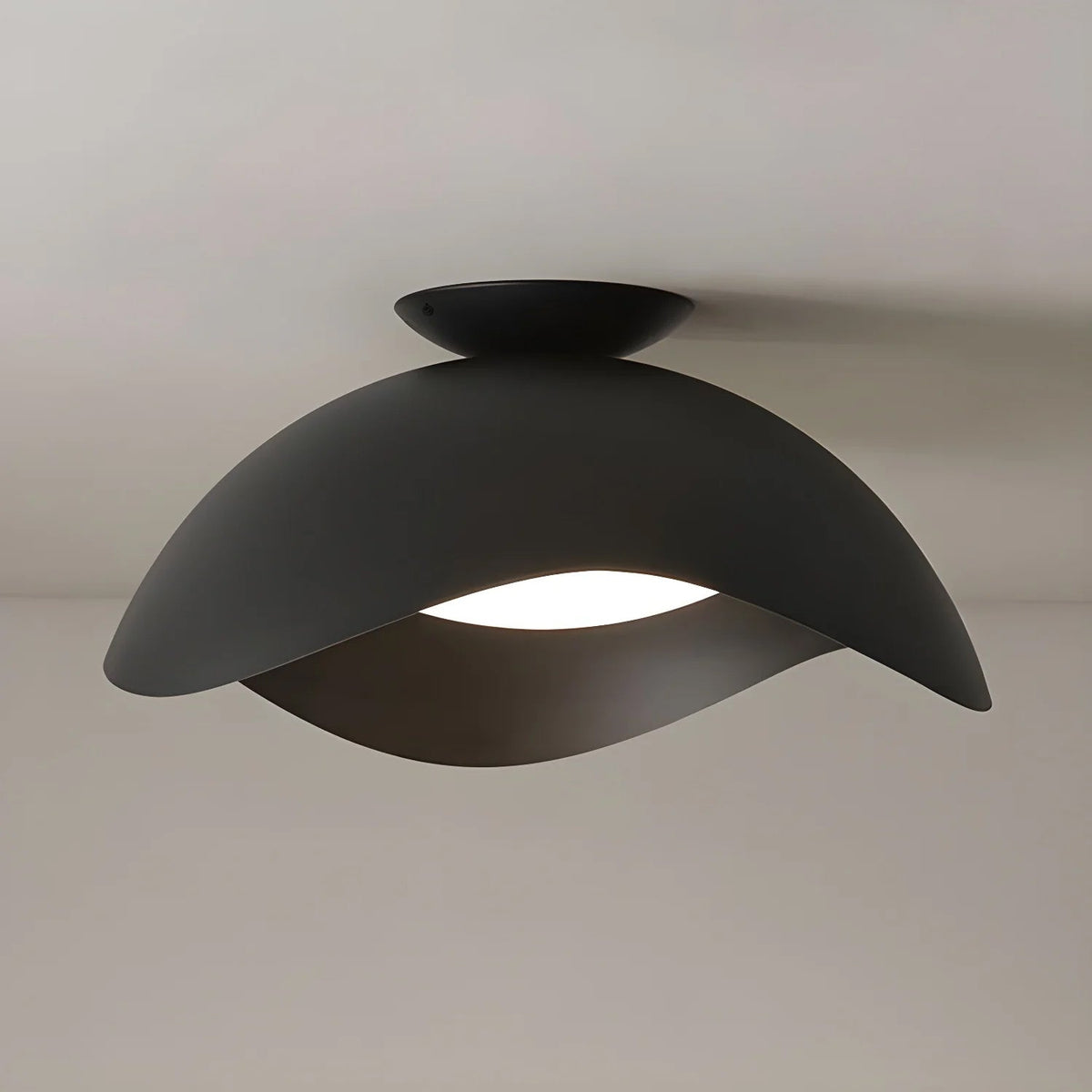 The matte black finish of this Clérachic ceiling light contrasts with its warm-lit shade underside.
