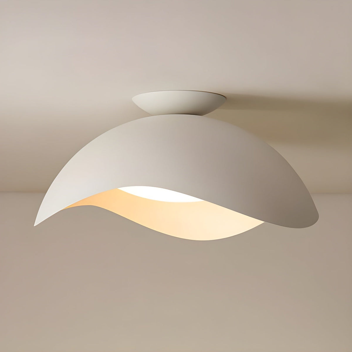This Clérachic ceiling light in white sits flush to a beige ceiling, its curved shade glowing warm from below.