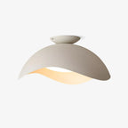 Studio view of this Clérachic wave-shaped ceiling light in white, its underside softly lit against a plain backdrop.